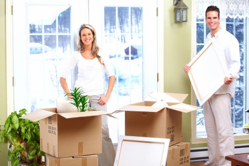 Removals team carrying belongings from a Stockwell flat with narrow access